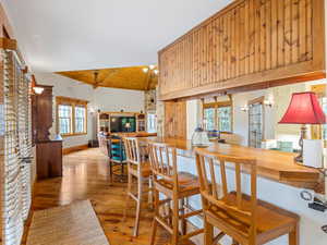 Dining room with wood ceiling, light wood-style floors, healthy amount of natural light, and vaulted ceiling