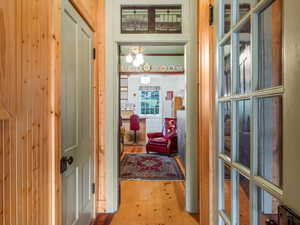 Hallway featuring wood-type flooring and a chandelier