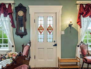 Doorway featuring baseboards and wood finished floors