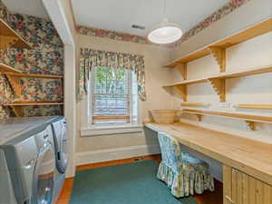 Tiled office space featuring washing machine and clothes dryer and wallpapered walls