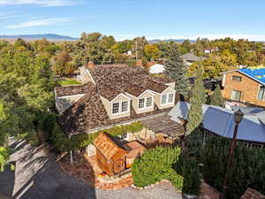 Aerial view of property and surrounding area featuring a tree filled landscape