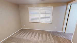 Empty room with carpet and baseboards