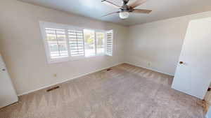 Empty room with carpet and ceiling fan