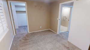 Spare room featuring light colored carpet and baseboards