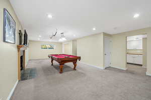 Playroom adjacent to second kitchen featuring recessed lighting, light carpet, billiards, and a fireplace