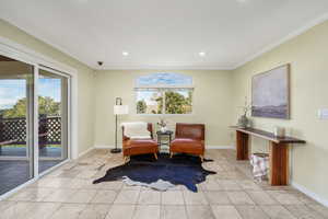 Living area featuring crown molding, recessed lighting, Travertine tile floors, and a sliding glass door to the sunroom