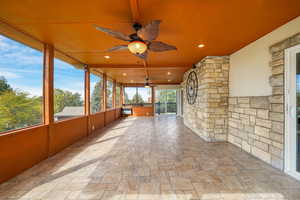 Sunroom with a ceiling fan and expansive windows