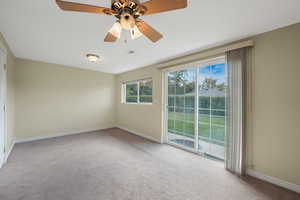 North bedroom with light colored carpet, ceiling fan, and sliding glass door
