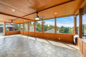 Sunroom with a ceiling fan and expansive windows