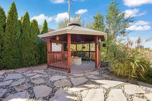 View of patio with a gazebo and an outdoor fire pit