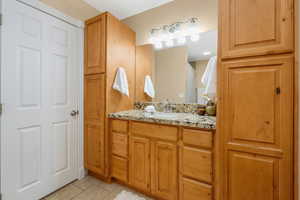 Full bath with vanity and light tile patterned floors