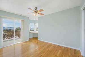 East Bedroom featuring hardwood floors, built in desk with 270* city and mountain views, and a private balcony