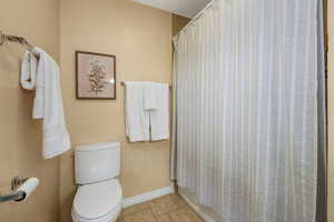 Bathroom with tile patterned flooring and shower / bath combo with shower curtain