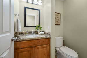 Main floor half bathroom featuring vanity and toilet