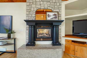 Primary Bedroom detailed view of wood finished floors and a fireplace