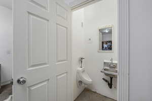 Half bath in garage featuring a urinal & sink