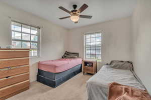 Bedroom featuring light carpet and a ceiling fan