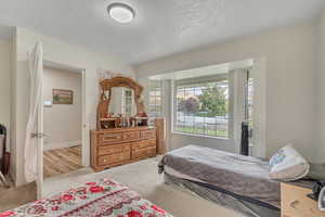 Bedroom featuring carpet and a textured ceiling