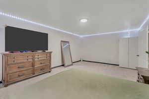 Bedroom featuring light carpet and baseboards