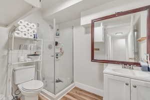 Full bath featuring a shower stall, vanity, and light wood-type flooring