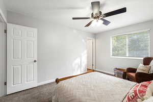 Bedroom with carpet flooring, ceiling fan, and a textured ceiling