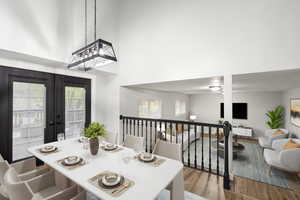 Dining area with a towering ceiling, wood finished floors, and french doors