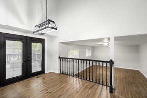 Foyer with a towering ceiling, wood finished floors, and french doors