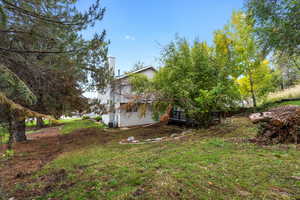 View of grassy yard featuring a wooden deck