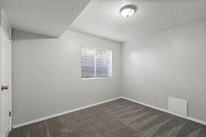 Empty room with carpet floors and a textured ceiling