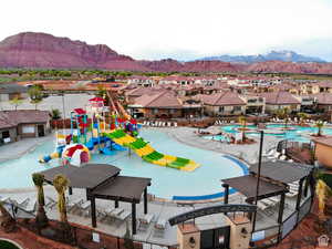 View of pool featuring a water play area, a residential view, a water slide, and a patio area