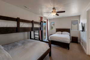 Bedroom with access to outside, carpet floors, and a ceiling fan