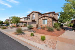 Mediterranean / spanish-style house with stucco siding, a garage, concrete driveway, stone siding, and a tile roof