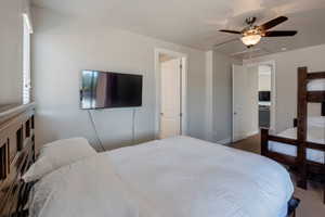 Bedroom with a ceiling fan and attic access