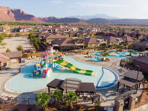 View of pool with a water play area, a residential view, a patio area, a water slide, and a mountain view