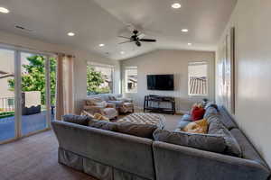Carpeted living room featuring lofted ceiling, recessed lighting, and ceiling fan