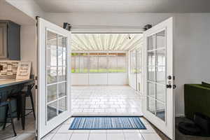 Entryway with tile patterned flooring and a sunroom