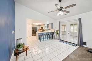 Foyer entrance with light tile patterned floors, lofted ceiling, french doors, a ceiling fan, and a textured ceiling
