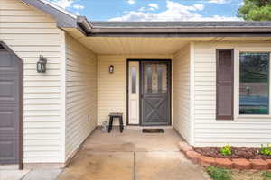 View of exterior entry featuring roof with shingles