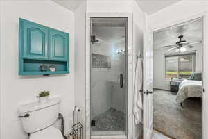 Bathroom featuring a stall shower, light carpet, ensuite bath, a textured ceiling, and ceiling fan