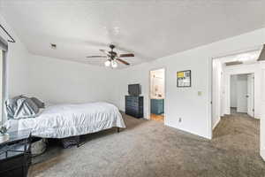 Carpeted bedroom featuring a textured ceiling and a ceiling fan