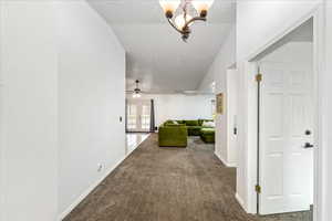 Hall with a textured ceiling, carpet flooring, french doors, and a chandelier