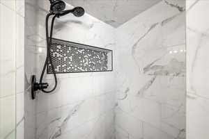 Bathroom featuring a marble finish shower