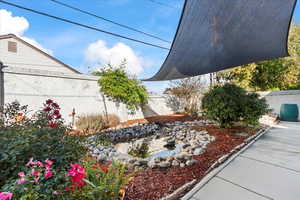 Fenced backyard with a small pond