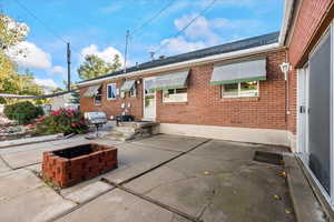Back of house featuring a patio area, brick siding, and an outdoor fire pit