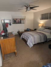 Bedroom featuring dark colored carpet, a textured ceiling, ceiling fan, and a baseboard radiator
