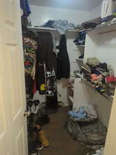 Walk in closet featuring dark carpet and a baseboard heating unit