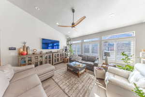 Living room featuring wood finished floors, ceiling fan, a textured ceiling, recessed lighting, and high vaulted ceiling