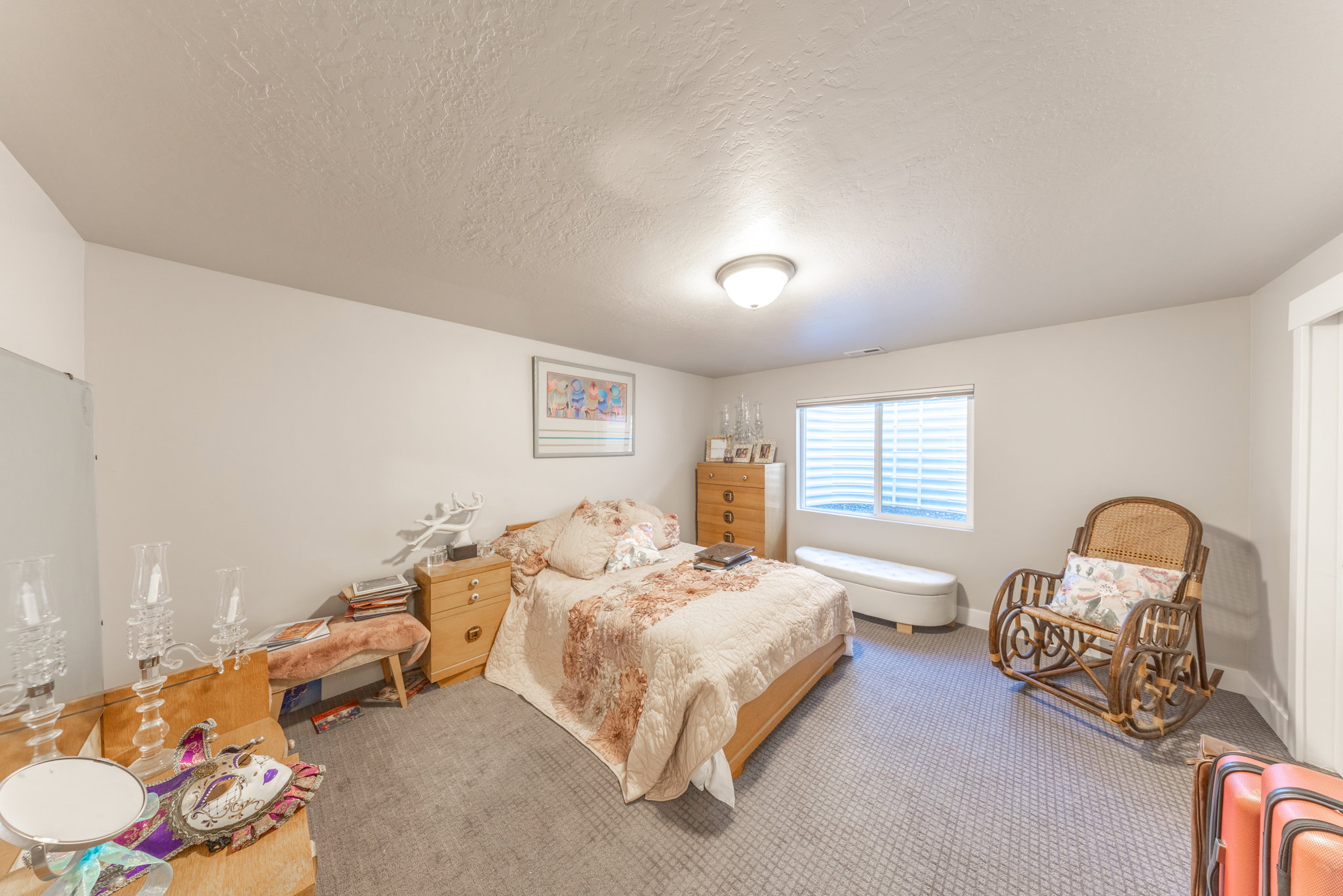 Carpeted bedroom with a textured ceiling and baseboards
