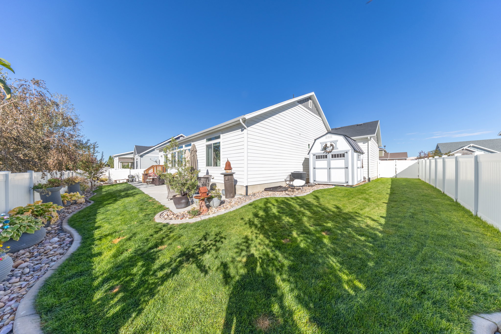 View of side of property featuring a fenced backyard, a storage shed, and a patio