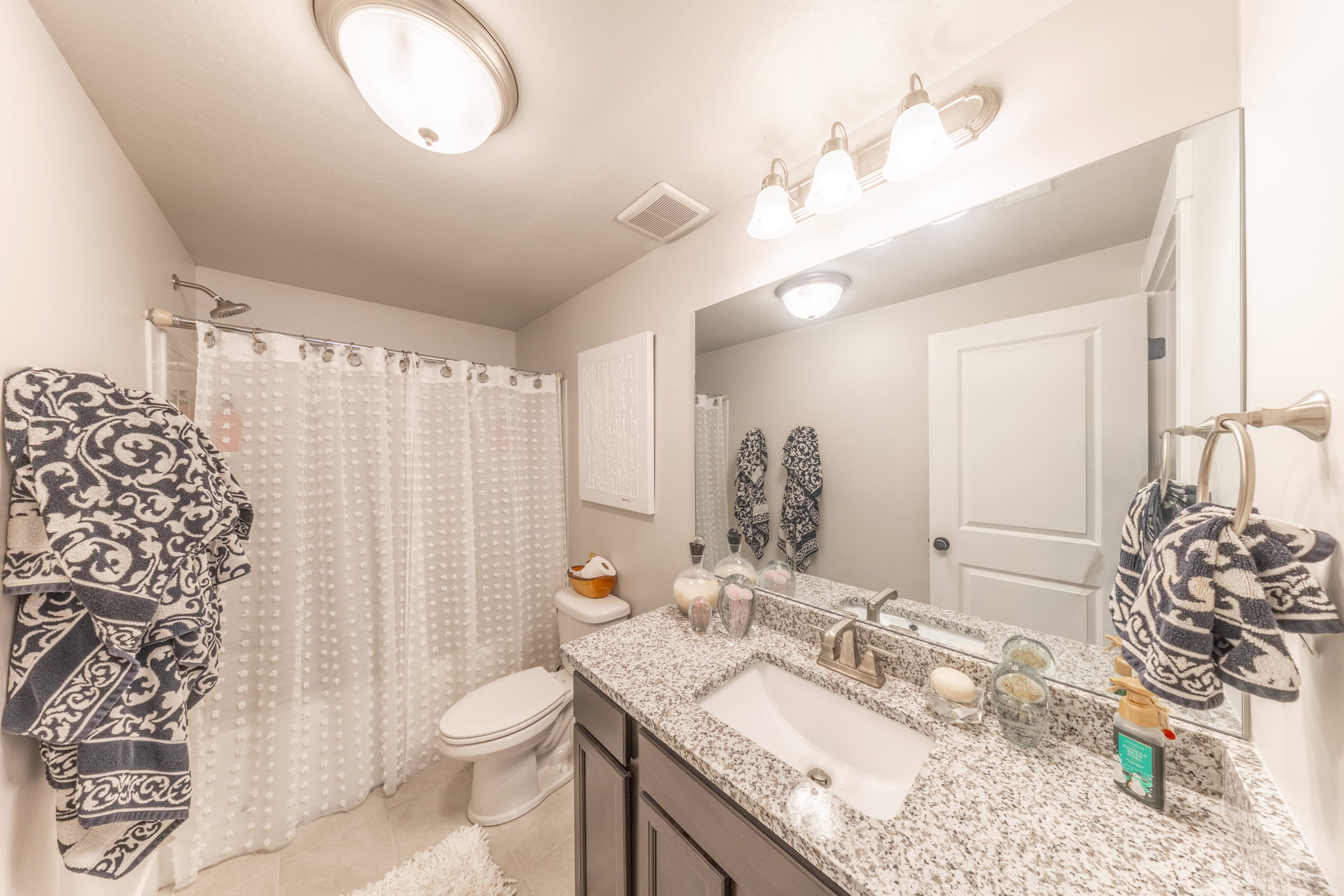 Full bath with a shower with curtain, vanity, and light tile patterned floors